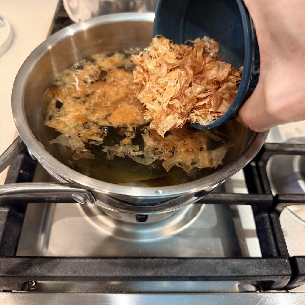 adding katsuobushi (dried bonito flakes) to homemade dashi