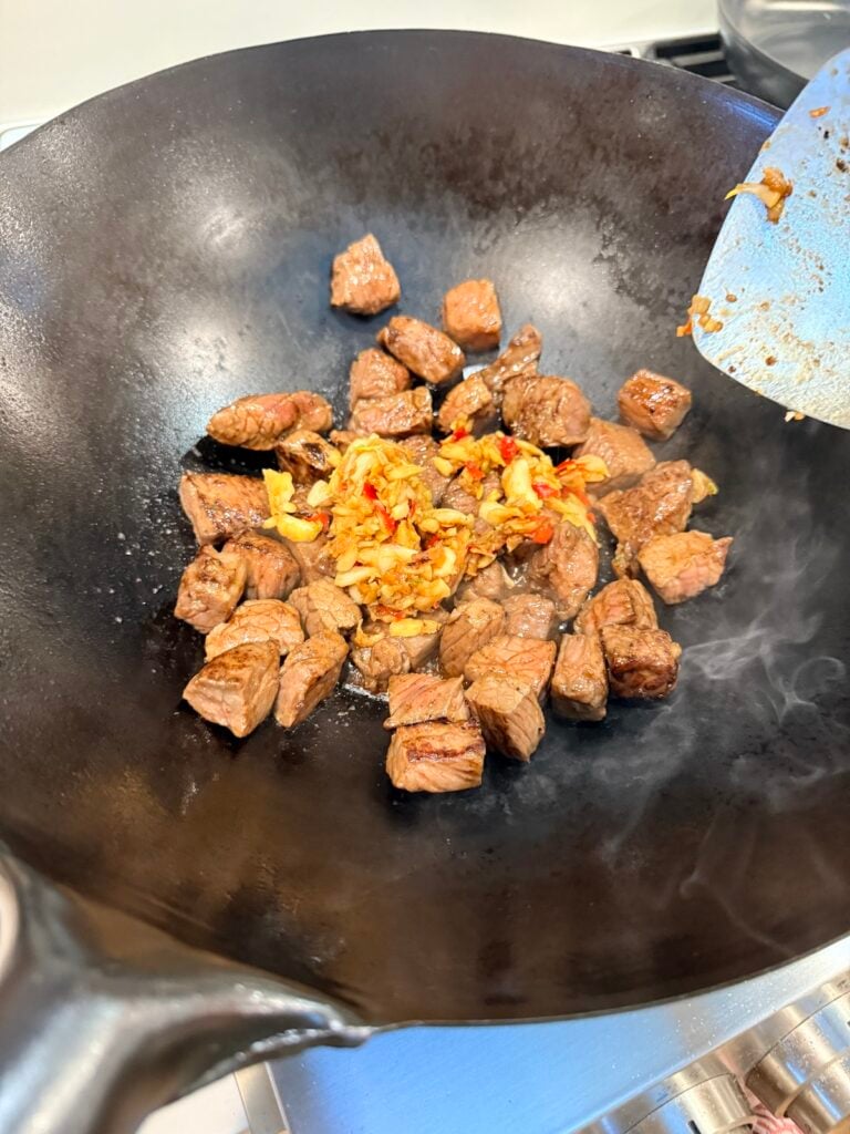 bougie pad gaprao with beef steak being cooked in a hot wok